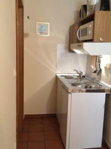 a small kitchen with a sink and a microwave at zum Aal in Wester-Ohrstedt