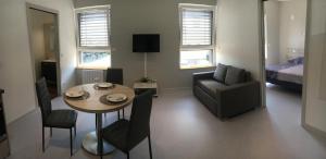 een kleine woonkamer met een tafel en een bank bij Le Nid des Coucous in Pulversheim