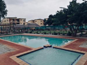 a large swimming pool with blue water in a yard at The Ultimate Escape - With Backup Electricity - Gaborone in Gaborone