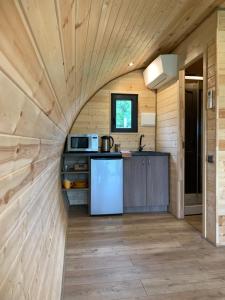 una cocina en una casa pequeña con paredes de madera en Kedras Glamping - Pod tipo nameliai en Prapuntai