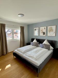 a bedroom with a large bed with white sheets at Schoko-Apartments mit Bad & Küche in Unterschneidheim