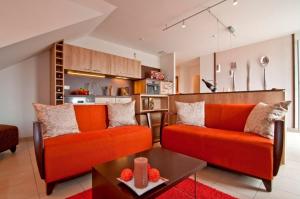 オストゼーバート・ニーンハーゲンにあるostseeLOGGIAのリビングルーム(オレンジ色のソファ2台、テーブル付)