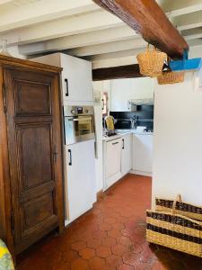 - une cuisine avec des appareils blancs et une porte en bois dans l'établissement LES GITES DU JARIEL, à Jouy-sur-Morin