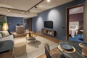 ein Wohnzimmer mit Sofa und Fernseher in der Unterkunft Van der Valk Hotel Haarlem in Haarlem