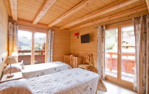 a bedroom with two beds in a room with windows at Odalys Chalet Le Renard Lodge in Les Deux Alpes