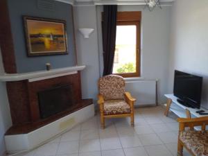 a living room with a fireplace and a chair and a television at Dikcati Pension in Şile