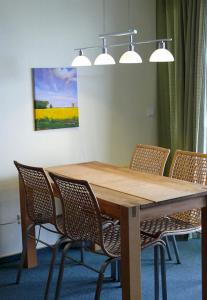 une table en bois avec des chaises et un tableau mural dans l'établissement Fehmarn- Ostseeferien FeWo Prusseit171, à Burgtiefe auf Fehmarn 