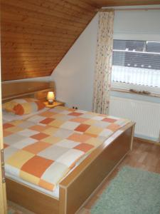 a bedroom with a checkered bed with a window at Ferienhaus Astrid in Osteel