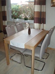 a dining room table and chairs with a table and a window at Ferienhaus Astrid in Osteel