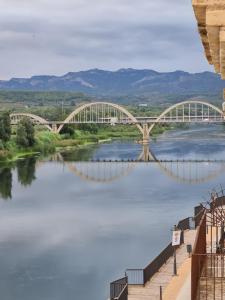 a bridge over a river next to a body of water at River Ebro Apartments in Móra d'Ebre