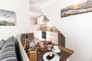 a small kitchen with a table with drinks and bottles of wine at M1 - Apartmenthaus Marienburger Str 4 - FERIENDOMIZIL HOLLICH in Grömitz
