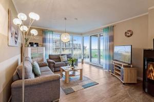 a living room with a couch and a tv at Relax Bungalow Muschelstrand in Klausdorf