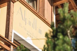 um sinal para um restaurante na lateral de um edifício em Chalet Residence Alpinflair em Ortisei