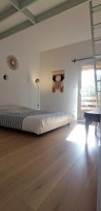 Un dormitorio con una cama grande y suelo de madera. en Charmante maisonnette, en Orléans