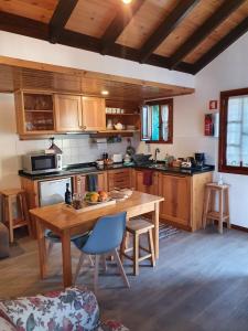 a kitchen with a wooden table and a kitchen with a tableablish at Palheiro da Adufa in São Vicente