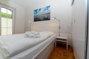SüdstrandにあるHaus Falsterの白いベッドルーム(ベッド1台、窓付)
