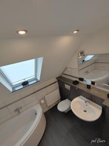 La salle de bains est pourvue de toilettes, d'une baignoire et d'un lavabo. dans l'établissement Modernes Ruhrgebietsdomizil, à Hattingen