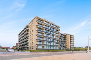 a tall apartment building on a city street at Refurbished comfortable app 1min from the sea in Koksijde