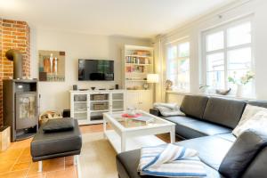 a living room with a couch and a table at Haus Windflüchter in Zingst