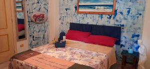 een slaapkamer met een bed en een bord aan de muur bij Casa d' Artista B&B in Ozieri