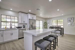 a kitchen with white cabinets and a large island with bar stools at Glendale Family Home Close to Golf and Westgate in Glendale