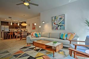 a living room with a couch and a table at Mid-Century Modern Phoenix Condo, Walk to High St! in Phoenix