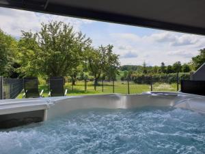 a jacuzzi tub with a view of a yard at Eifel Dream Kalkmulde in Fleringen