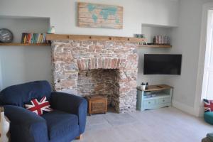 a living room with a brick fireplace with a tv at Luxury dog friendly home in Brixham harbour with sea views and free parking in Brixham