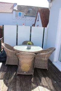 a patio table and chairs on a balcony at LANDHAUS AM HAFEN im OG in Heiligenhafen