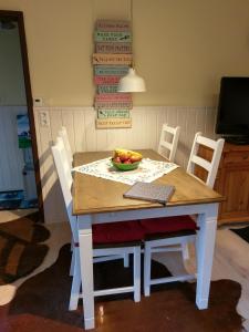 una mesa y sillas con un bol de fruta. en Ferienhaus Dornhecke, en Hatzfeld