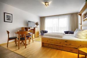 ツィングストにあるOstsee-Residenz Whg 12のベッドとダイニングルームが備わるホテルルームです。