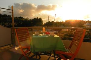 a table and chairs on a balcony with the sunset at Ostsee-Residenz Whg 12 in Zingst