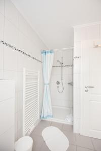 a white bathroom with a tub and a shower at Wohnung 1 in Fehmarn