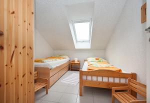 una camera mansardata con due letti e una finestra di Wohnung 1 a Fehmarn