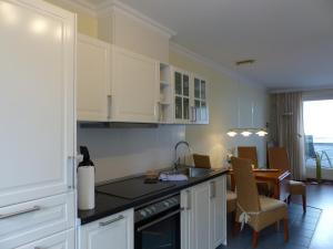a kitchen with white cabinets and a table with a dining room at 470er Ferienwohnung in Laboe