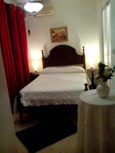 a bedroom with a bed and a table with two lamps at Residência Matos Pereira in Vila Real de Santo António