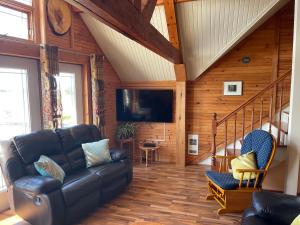 Una sala de estar con un sofá y un televisor. en Beach & Breeze Cottages, en Stanley Bridge