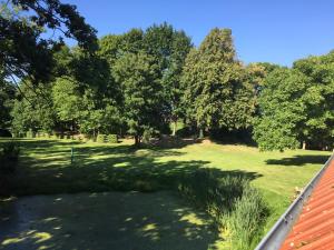 a park with trees and grass and a roof at Blauer Salon in Satow