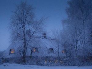 a house is covered in snow at night at Altes Rektorenhaus 1 in Rieseby