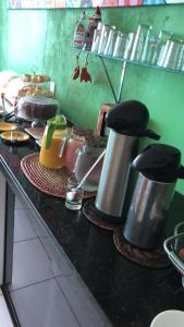 un comptoir dans une cuisine avec des casseroles et des poêles dans l'établissement Pousada Verde Suites, à Porto de Galinhas