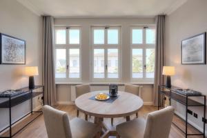 - une salle à manger avec une table, des chaises et des fenêtres dans l'établissement Villa Seeblick "Balmer See", à Ahlbeck