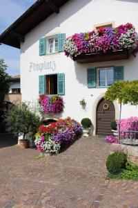 Un edificio blanco con muchas flores. en Amplatz 1523 - B&B and Suites, en Montagna