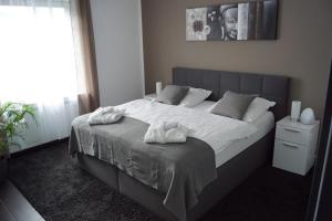 a bedroom with a large bed with white towels on it at La Domus Superior Osnabrück Lotte in Lotte