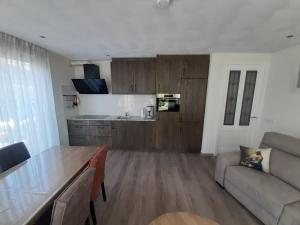 a kitchen and living room with a table and a couch at de Kempenvallei in Luyksgestel