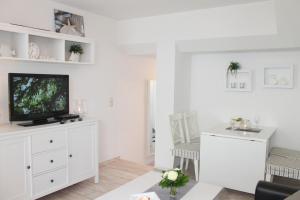 ein Wohnzimmer mit einem TV auf einer weißen Kommode in der Unterkunft Ferienwohnung Steffens - "Mittelweg" in Grömitz