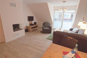 sala de estar con sofá y chimenea en Les Belles, Haus Bastien, FW Noble, Whg 9 en Zingst