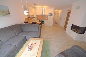 a living room with a gray couch and a fireplace at Les Belles, Haus Bastien, FW Noble, Whg 9 in Zingst