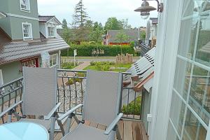 un porche con 2 sillas y una mesa en el balcón en Les Belles, Haus Bastien, FW Noble, Whg 9 en Zingst