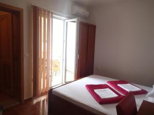 a bedroom with a bed with red towels on it at Villa Bosac in Gradac