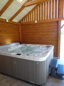 a hot tub in a room with a wooden ceiling at Melody Huis in Poroszló